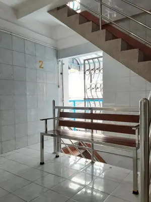 a bench in a room with a staircase at New Central Guesthouse in Bangkok