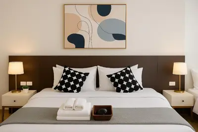 a bedroom with a large bed with black and white pillows at Spacious 2 King Beds, Balcony with View, Near Nana BTS in Bangkok