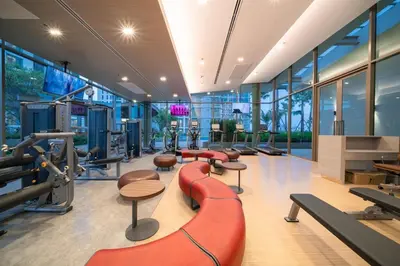 a gym with a red bench and tables and chairs at Amazing Pool and Luxury Condo Unit Near Phrom Phong BTS in Bangkok