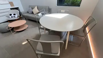 a living room with a white table and chairs at Tree Villa Bangkok in Bangkok