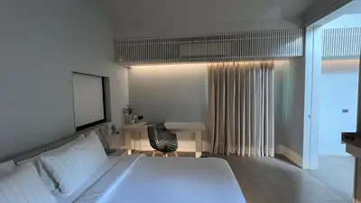 a bedroom with a white bed and a desk at Tree Villa Bangkok in Bangkok