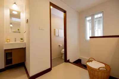 a bathroom with a mirror and a sink and a toilet at Kraft Haus in Khlong San