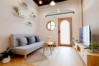 a living room with a couch and a tv at Kraft Haus in Khlong San