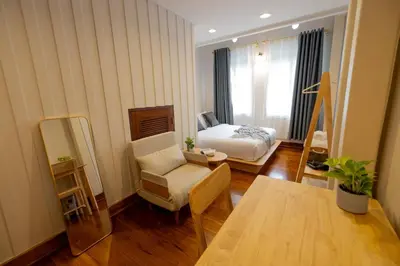 a room with a bed and a chair and a table at Kraft Haus in Khlong San