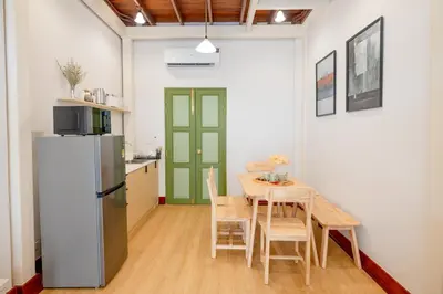 a kitchen and dining room with a table and a refrigerator at Kraft Haus in Khlong San