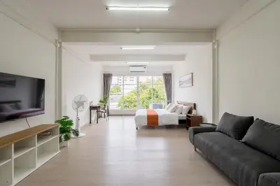 a living room with a couch and a bed at Glow House Sukhumvit 54 in Bangkok