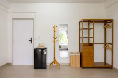 a room with a mirror and a wooden cabinet at Glow House Sukhumvit 54 in Bangkok