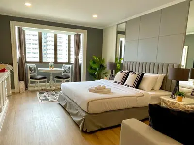a large bedroom with a large bed and a table at Vibrant City Retreat 6 Mins Walk BTS Nana, 1BR in Bangkok