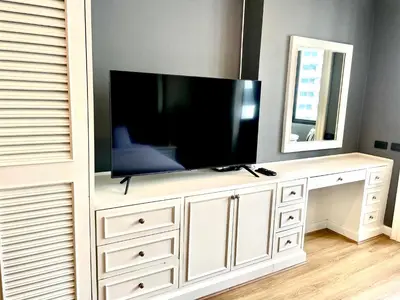 a flat screen tv on a white entertainment center at Vibrant City Retreat 6 Mins Walk BTS Nana, 1BR in Bangkok