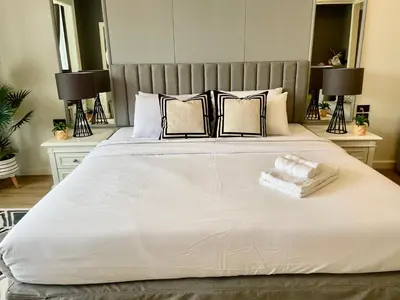 a bedroom with a large white bed with two lamps at Vibrant City Retreat 6 Mins Walk BTS Nana, 1BR in Bangkok