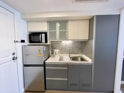 a small kitchen with a sink and a refrigerator at Vibrant City Retreat 6 Mins Walk BTS Nana, 1BR in Bangkok