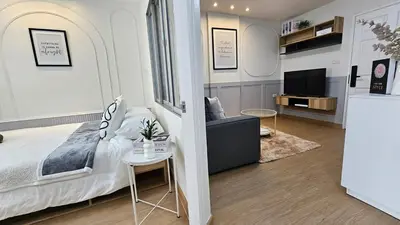 a bedroom with a bed and a living room with a tv at Easy Living in Bang Khen