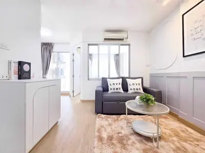a living room with a couch and a table at Easy Living in Bang Khen