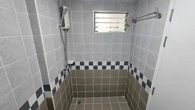 a bathroom with a shower with black and white tiles at Easy Living in Bang Khen