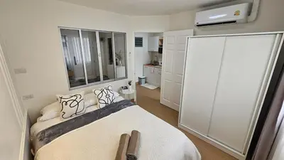 a bedroom with a bed and a large mirror at Easy Living in Bang Khen