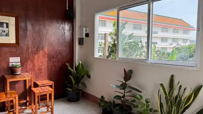 a room with a window and a table and plants at Baan PadSeeEw - Rooftop Riverview 3rd floor in Thonhuri
