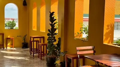 a restaurant with tables and chairs and a potted plant at Baan PadSeeEw - Rooftop Riverview 3rd floor in Thonhuri