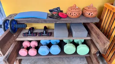 a wooden shelf with different colored bottles and vases at Baan PadSeeEw - Rooftop Riverview 4th floor in Thonhuri