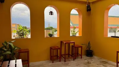 a room with three arched windows and four stools at Baan PadSeeEw - Rooftop Riverview 4th floor in Thonhuri