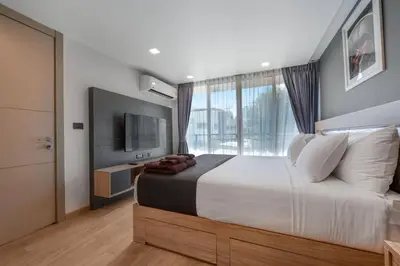 a bedroom with a large bed and a large window at Alcove 53 in Bangkok