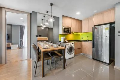 a kitchen and dining room with a table and a refrigerator at Alcove 53 in Bangkok