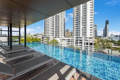 a large swimming pool in a building with tall buildings at Alcove 53 in Bangkok