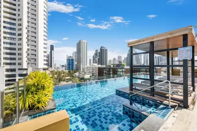a swimming pool on the roof of a building with a city skyline at Alcove 53 in Bangkok