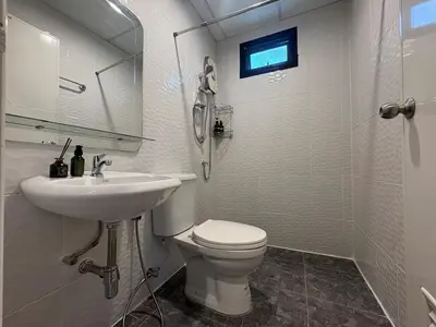 a white bathroom with a toilet and a sink at Cozy Canal House 1 min to MRT & Street Foods in Bangkok