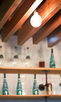 a row of green glass vases on a shelf at Diamond Residence Ratchada in Bangkok