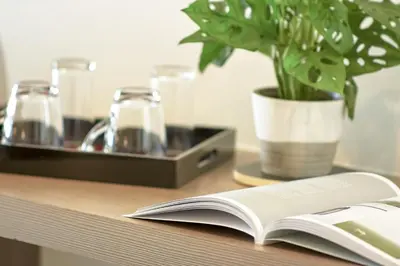 an open book on a table with a potted plant at Diamond Residence Ratchada in Bangkok