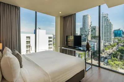 a bedroom with a bed and a large window at The Residence on Thonglor by UHG in Bangkok