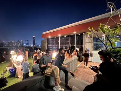 a group of people sitting outside of a building at The Residence on Thonglor by UHG in Bangkok