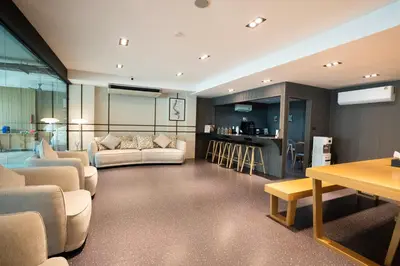 a large living room with couches and a kitchen at Infinite Hotel-Ratchada in Bangkok