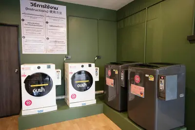 three washing machines are lined up in a room at Infinite Hotel-Ratchada in Bangkok