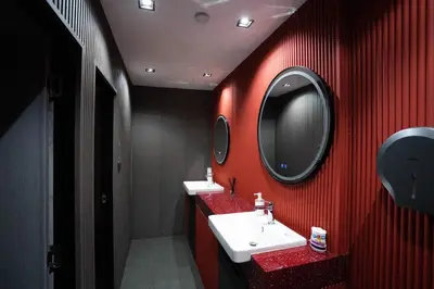 a red bathroom with a sink and a mirror at Infinite Hotel-Ratchada in Bangkok