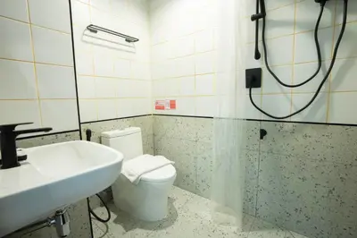 a bathroom with a toilet and a sink at Infinite Hotel-Ratchada in Bangkok