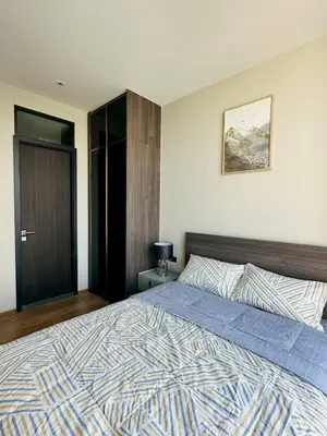 a bedroom with a large bed with a blue comforter at The Fine 2-bedroom in Bangkok