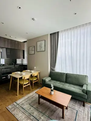 a living room with a green couch and a table at The Fine 2-bedroom in Bangkok