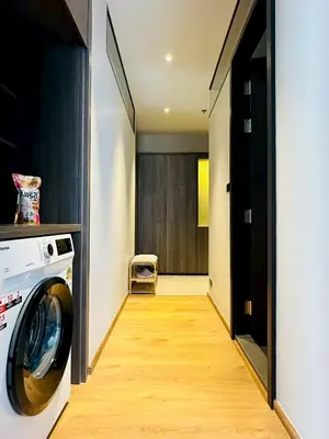 a laundry room with a washing machine and a hallway at The Fine 2-bedroom in Bangkok