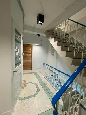 an empty hallway with stairs and a blue railing at Comfy Corner Hostel in Bangkok