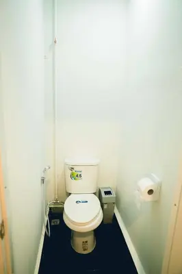 a small bathroom with a toilet in a stall at Comfy Corner Hostel in Bangkok
