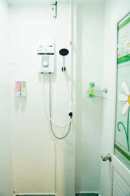 a shower in a white room with a hose at Comfy Corner Hostel in Bangkok