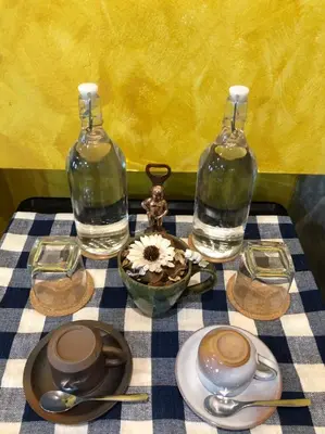 a table with two glass bottles and a flower in a bowl at Double Studio with Balcony & Private Bath by Smile Loft in Bangkok