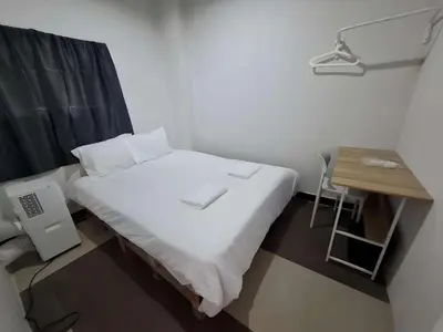a small bed in a room with a desk and a bed sidx sidx at XX The Hidden Khaosan - เดอะฮิดเด้นถนนข้าวสาร รามบุตรี in Bangkok