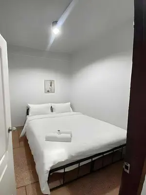 a white bed in a white bedroom with a light at XX The Hidden Khaosan - เดอะฮิดเด้นถนนข้าวสาร รามบุตรี in Bangkok