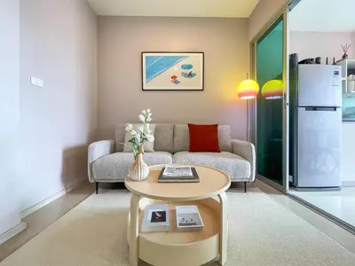 a living room with a couch and a table at Functional and comfortable-FastWiFi-MRT HuaiKhwang in Bangkok