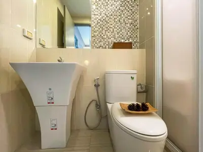 a bathroom with a white toilet and a sink at Functional and comfortable-FastWiFi-MRT HuaiKhwang in Bangkok