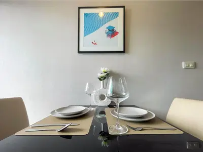 a dining room table with two plates and glasses at Functional and comfortable-FastWiFi-MRT HuaiKhwang in Bangkok