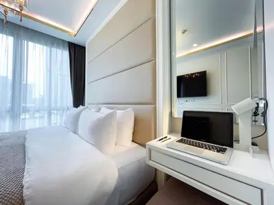 a hotel room with a bed and a laptop on a desk at Comfortable Stay 1BR - Ultra Fast Wifi - Huai Khwang in Bangkok