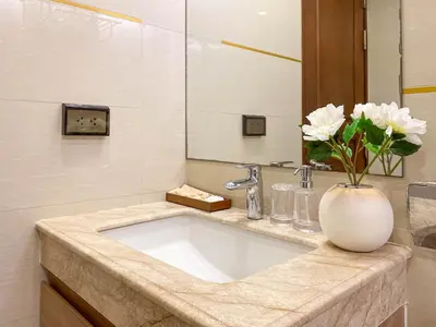 a bathroom with a sink with a vase of flowers at Comfortable Stay 1BR - Ultra Fast Wifi - Huai Khwang in Bangkok